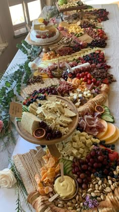 a long table filled with lots of different types of cheeses and crackers on it