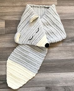 a crocheted dog scarf laying on top of a wooden floor