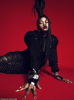 a woman with long black hair is laying on the ground and holding her hands out