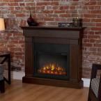 an electric fireplace in a living room with brick wall and wood flooring on the side