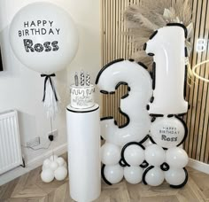 balloons and decorations for a birthday party with the number one on it's side