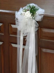 a bouquet of flowers tied to the side of a wooden door with ribbon on it