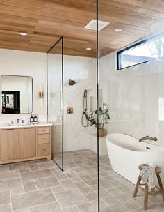 a bathroom with a tub, sink, mirror and stool in it's center