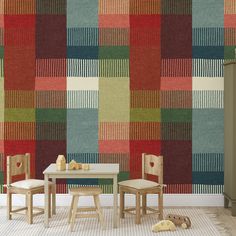 two children's chairs and table in front of a multicolored wallpaper