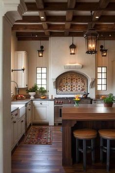 a large kitchen with an island in the center and two stools at the end