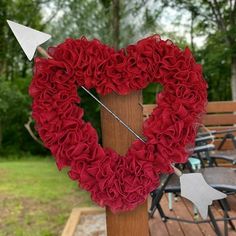 a heart shaped wreath with an arrow sticking out of it