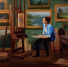 a woman sitting in front of an easel painting