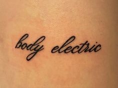 the word body electric written in cursive black ink on a woman's lower back