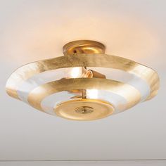 a close up of a ceiling light with white and gold stripes on the rims