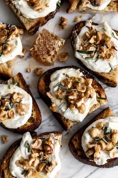 toasted bread topped with whipped cream and walnuts on a white marble countertop