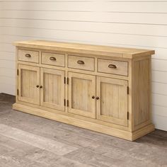 a large wooden cabinet sitting on top of a hard wood floor next to a white wall