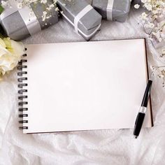 a notepad and pen sitting on top of a table next to wrapped gift boxes