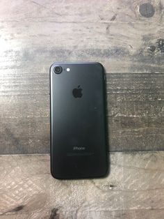 an iphone sitting on top of a wooden table