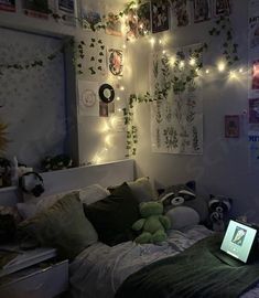 a bedroom with lights strung from the ceiling and stuffed animals on the bed in front of it