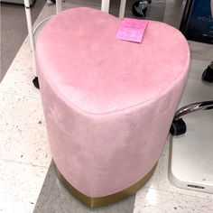 a pink heart shaped ottoman sitting on top of a floor