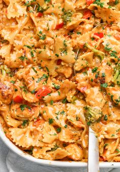 a casserole dish filled with pasta, chicken and veggies in a creamy sauce