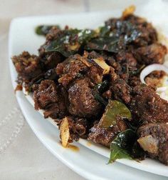 a white plate topped with meat and rice