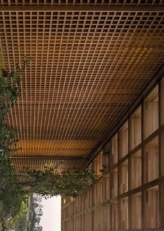 an outdoor area with benches and plants on the side of the building that is covered in wood slats