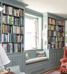 a living room filled with lots of furniture and bookshelves next to a window