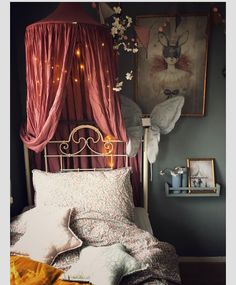 an image of a bed with pink sheets and curtains on it's headboard