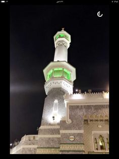 a tall white tower with a clock on it's side at night time,