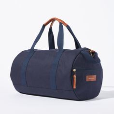 Sporty pals, we’ve had our not-so-sporty-bags stolen just one too many times, so we made you your own. Fabricated of our durable yet lightweight 12 oz canvas and accented with tonal navy webbing this is the perfect grab and go bag. A pair of sneakers, change of clothes, and shower essentials and we’ll have you from the gym to the office in no time. Carry the duffle with the handles or sling it over your shoulder with the removable strap. Sporty Canvas Gym Bag, Functional Cotton Bag For Overnight Trips, Functional Cotton Travel Bag For Overnight Trips, Sporty Canvas Bags For Daily Use, Sporty Cotton Canvas Travel Bag, Sporty Cotton Travel Bag, Sporty Everyday Canvas Bag, Classic Canvas Duffle Bag For Daily Use, Casual Navy Bag For Outdoor