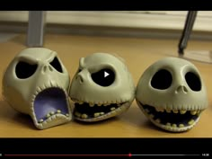 three fake skulls with mouths open sitting on a table