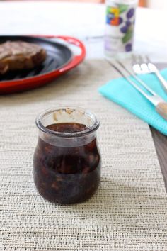 a glass jar filled with food sitting on top of a table next to a plate