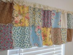 the curtain is hanging on the wall with many different colors and patterns, including flowers