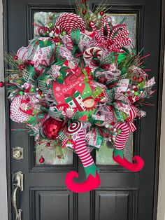 a christmas wreath with candy canes and santa's stockings on the front door