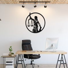 a wooden desk topped with a computer next to a wall mounted clock on the side of a white wall