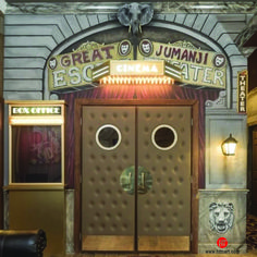 an entrance to a movie theater with two large doors that have faces on the front