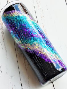 a canister with glitter on it sitting on top of a white table next to a cell phone