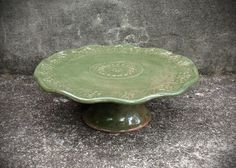 a green plate sitting on top of a cement floor