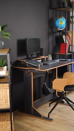 a desk with a chair and computer on it in front of a bookshelf