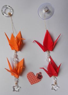 three origami birds are hanging on the wall next to a wine glass holder