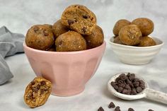 a bowl full of cookies and chocolate chips next to a spoon