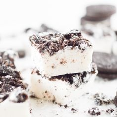 two pieces of cake sitting on top of a white table next to cookies and oreos