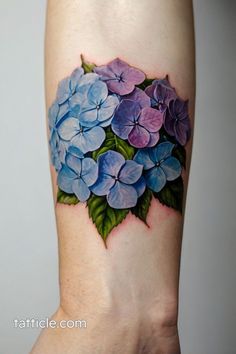 a tattoo with blue and purple flowers on it