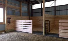 the inside of a barn with wooden stalls