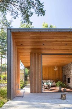 an outdoor living area with wood paneling and stone fireplace