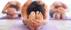 a group of women doing yoga poses in the middle of a room with their hands together