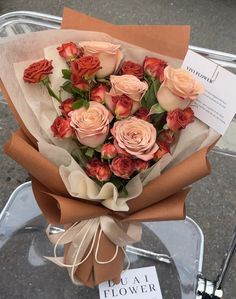 a bouquet of roses is wrapped in brown paper