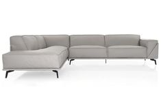 a gray sectional couch sitting on top of a white floor