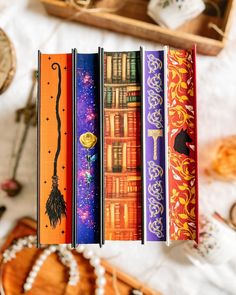 four books are lined up on a table next to some beads and other items in the background