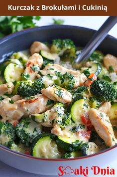 a bowl filled with chicken, zucchini and broccoli covered in sauce