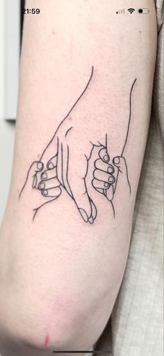 two hands holding each other on the left side of the arm, with one hand pointing towards