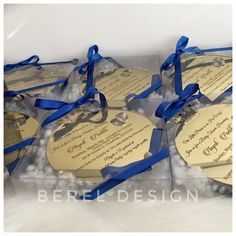 six wedding favors with blue ribbons in a clear gift box on top of some snow