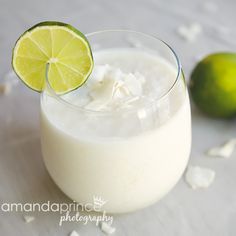 a close up of a drink with a lime on the rim