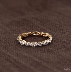 a gold and diamond ring on a brown background